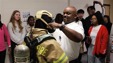 Showing students how to put on fire gear